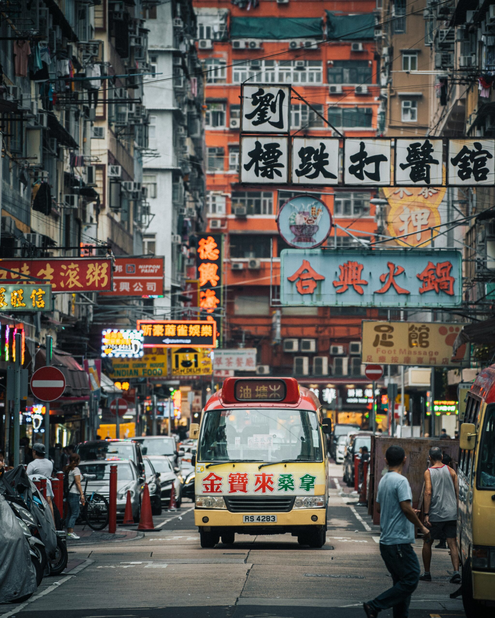 A busy urban street in Hong Kong, filled with colorful neon signs, traditional Chinese characters